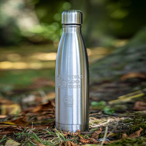 World Land Trust Metal Waterbottle, silver 500ml bottle in a woodland setting.